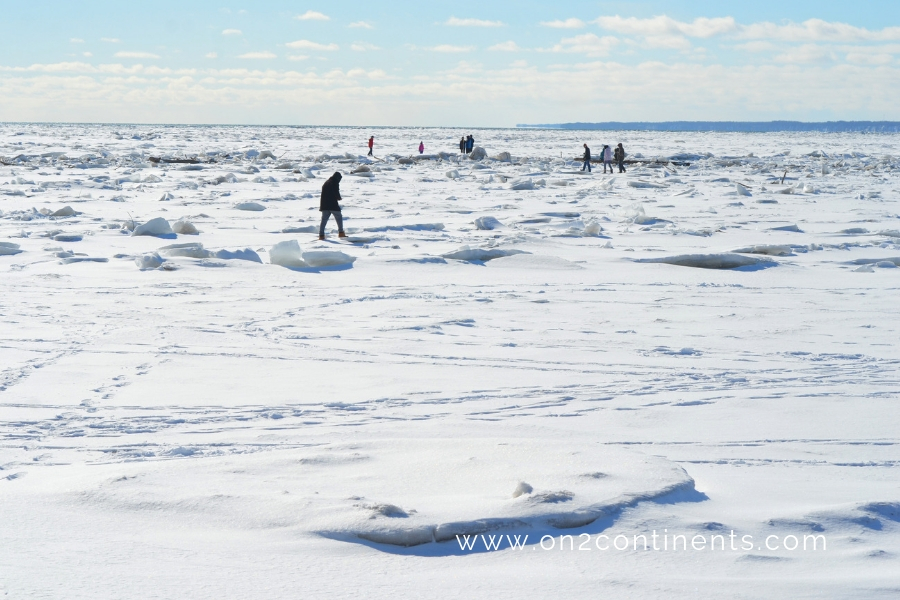 Dreamy frozen Lake Erie landscape with people walking on the ice.