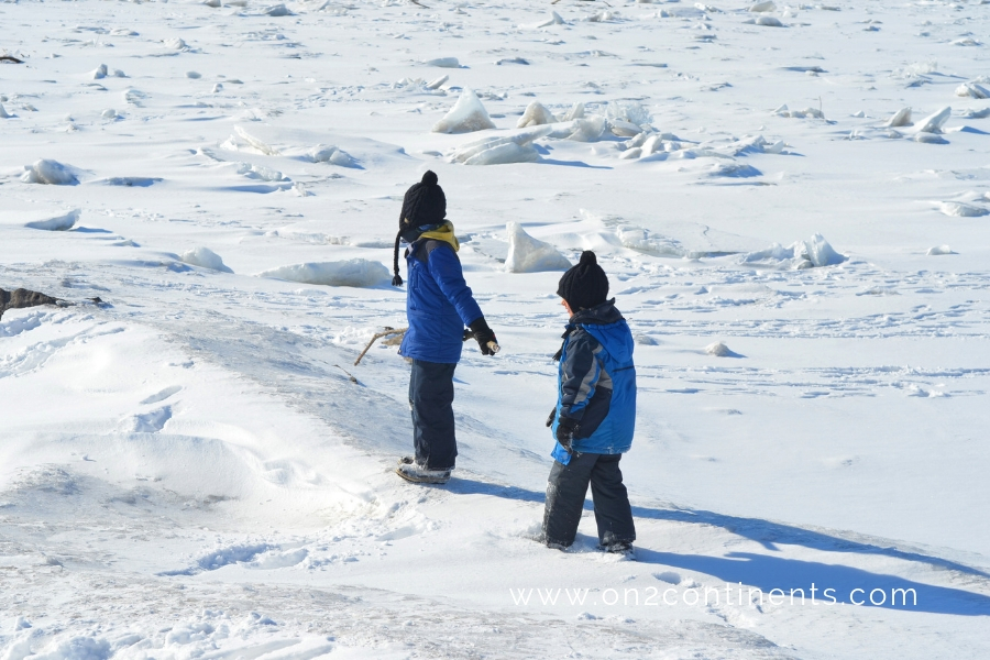 Children walking on frozen lake. Scenic winter lake landscpe.