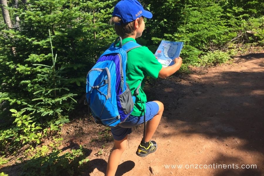 Young boy hiking with a map in his hand